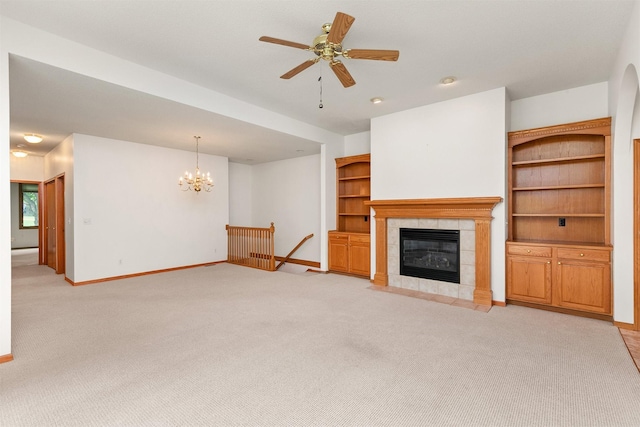 6799 NW 57th St, Johnston, IA 50131 - unfurnished living room featuring light colored carpet, baseboards, a chandelier, a tiled fireplace, and a ceiling fan