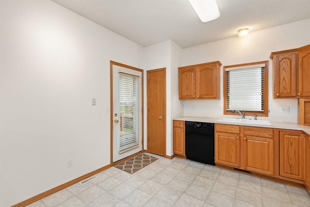 6799 NW 57th St, Johnston, IA 50131 - kitchen featuring black dishwasher, a sink, light countertops, and light floors
