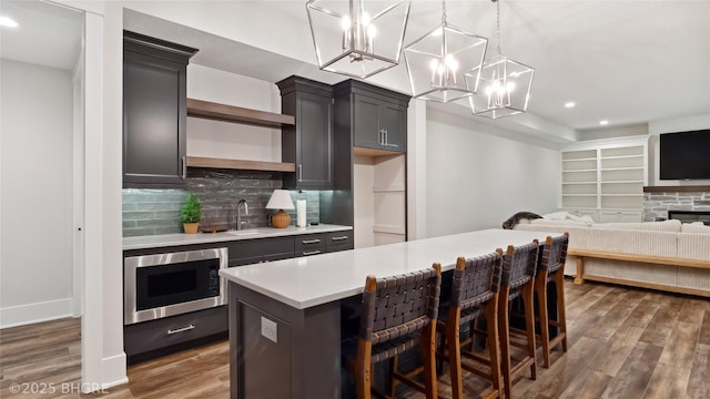 815 S Kingswood Ct, West Des Moines, IA 50266 - kitchen with built in microwave, open shelves, wood finished floors, light countertops, and a sink