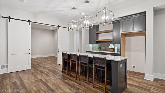 815 S Kingswood Ct, West Des Moines, IA 50266 - kitchen featuring a barn door, light countertops, a center island, baseboards, and recessed lighting