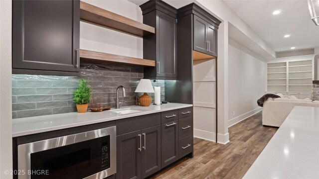 815 S Kingswood Ct, West Des Moines, IA 50266 - kitchen with a sink, open shelves, stainless steel microwave, light countertops, and baseboards