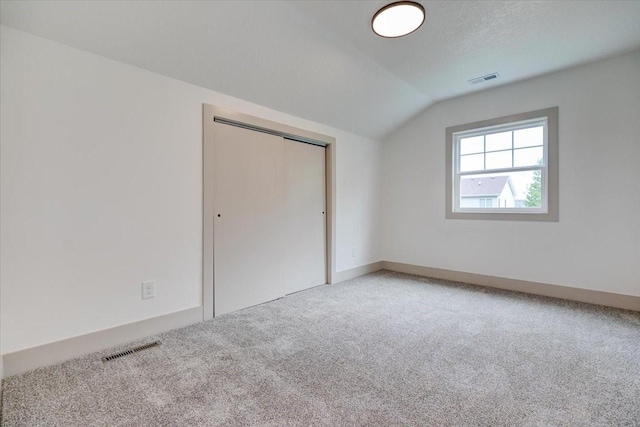 801 SE 5th St, Grimes, IA 50111 - unfurnished bedroom with lofted ceiling, carpet flooring, and a closet