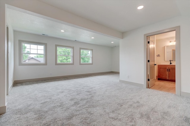 801 SE 5th St, Grimes, IA 50111 - empty room with light colored carpet, plenty of natural light, recessed lighting, baseboards, and a sink