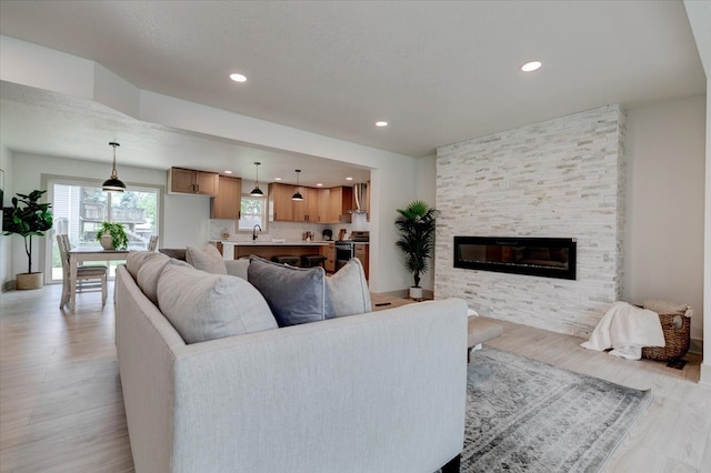 801 SE 5th St, Grimes, IA 50111 - living room featuring light wood-type flooring, a fireplace, recessed lighting, and baseboards