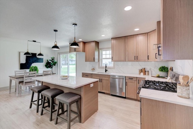 801 SE 5th St, Grimes, IA 50111 - kitchen with stainless steel dishwasher, a sink, a breakfast bar area, a kitchen island, and decorative backsplash