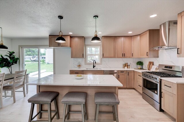 801 SE 5th St, Grimes, IA 50111 - kitchen featuring gas stove, wall chimney exhaust hood, a sink, a kitchen bar, and tasteful backsplash