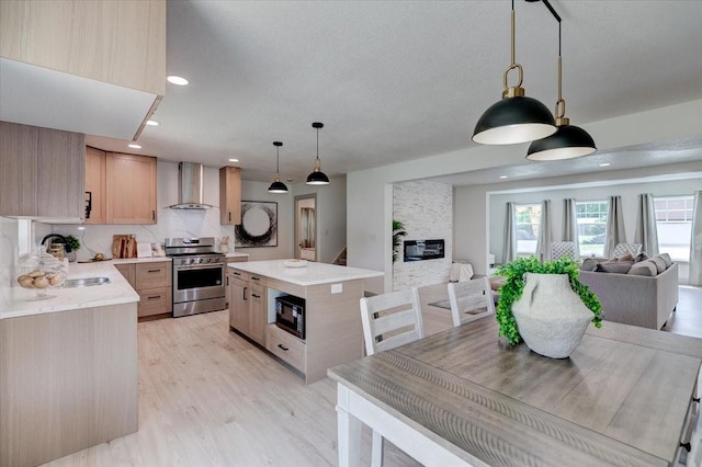 801 SE 5th St, Grimes, IA 50111 - kitchen featuring stainless steel gas range oven, black microwave, wall chimney range hood, a sink, and light countertops