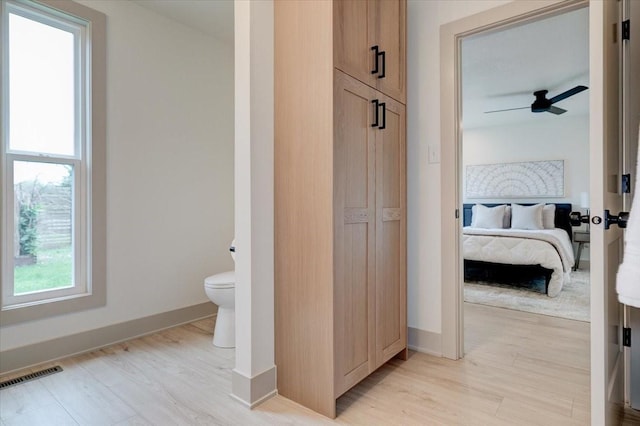 801 SE 5th St, Grimes, IA 50111 - ensuite bathroom featuring toilet, wood finished floors, baseboards, and a ceiling fan