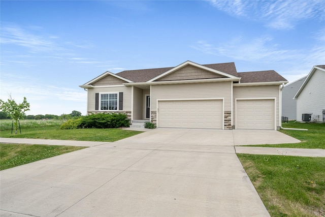 9334 Valley Pkwy, Johnston, IA 50131 - ranch-style house featuring a garage, a front lawn, concrete driveway, cooling unit, and stone siding