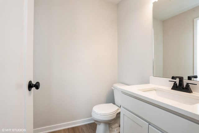 2925 6th Ave SW, Altoona, IA 50009 - bathroom featuring wood finished floors, toilet, vanity, and baseboards