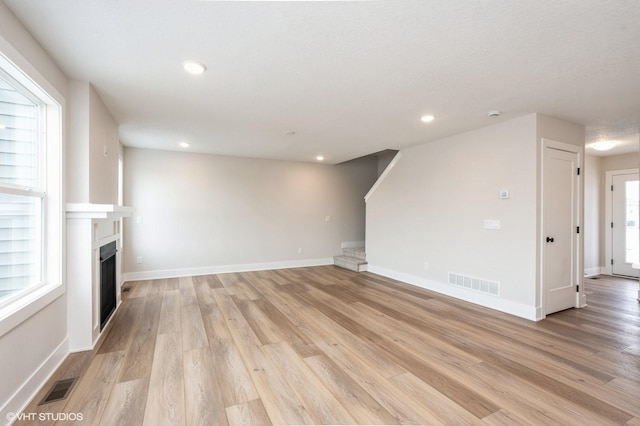 2925 6th Ave SW, Altoona, IA 50009 - unfurnished living room featuring light wood-type flooring, a fireplace, stairs, recessed lighting, and baseboards