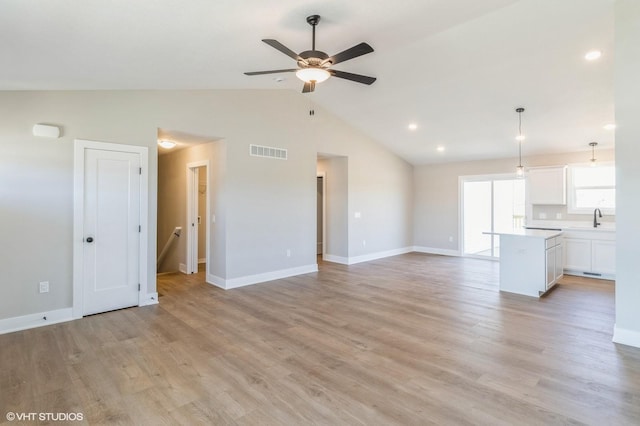 3002 6th Ave SW, Altoona, IA 50009 - unfurnished living room featuring ceiling fan, a sink, baseboards, light wood-style flooring, and high vaulted ceiling