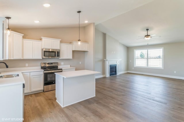 3002 6th Ave SW, Altoona, IA 50009 - kitchen featuring stainless steel appliances, a sink, vaulted ceiling, a kitchen island, and a ceiling fan