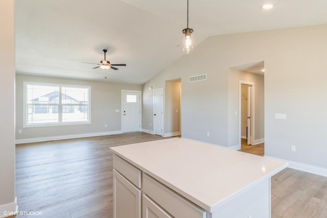 3002 6th Ave SW, Altoona, IA 50009 - kitchen featuring lofted ceiling, white cabinets, light wood-style floors, a ceiling fan, and light countertops