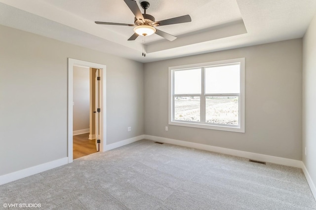 3002 6th Ave SW, Altoona, IA 50009 - unfurnished room featuring light colored carpet, a tray ceiling, and baseboards
