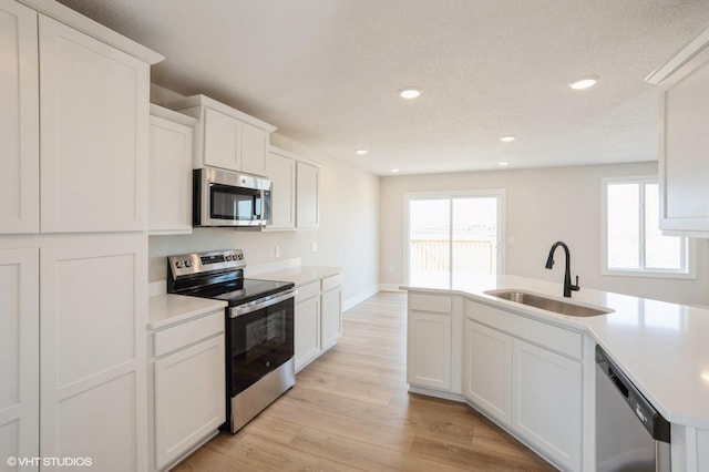 3010 6th Ave SW, Altoona, IA 50009 - kitchen with appliances with stainless steel finishes, a sink, light wood-style floors, light countertops, and recessed lighting