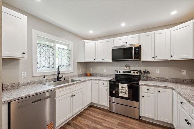 204 W Washington St, Montezuma, IA 50171 - kitchen with appliances with stainless steel finishes, a sink, white cabinets, dark wood-style flooring, and recessed lighting