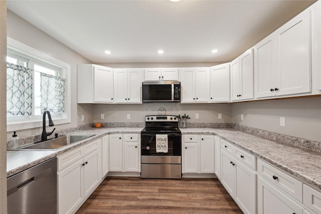 204 W Washington St, Montezuma, IA 50171 - kitchen with stainless steel appliances, a sink, dark wood-type flooring, white cabinets, and light countertops