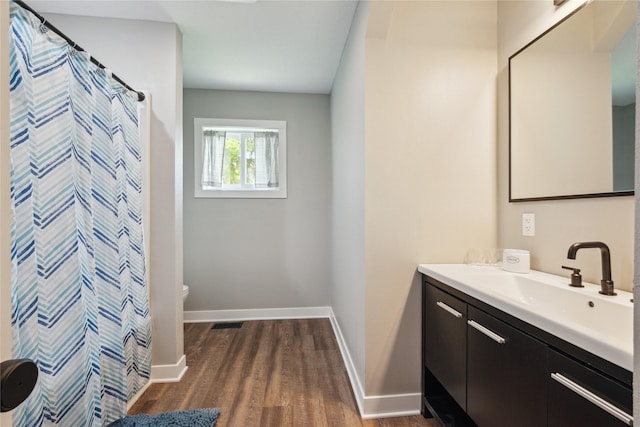 204 W Washington St, Montezuma, IA 50171 - full bath featuring toilet, wood finished floors, vanity, baseboards, and a shower with curtain