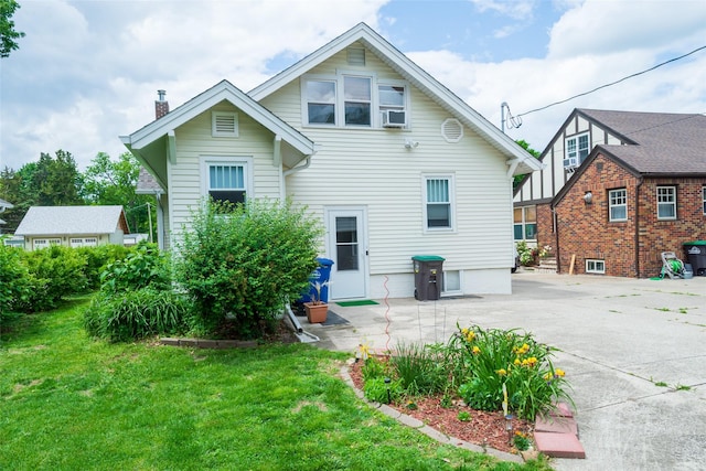 1055 40th St, Des Moines, IA 50311 - rear view of property featuring a chimney, a lawn, a patio area, and cooling unit