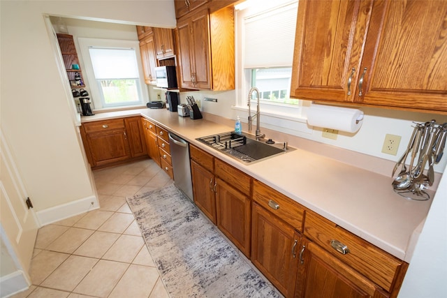 1055 40th St, Des Moines, IA 50311 - kitchen with dishwasher, a sink, brown cabinetry, light tile patterned floors, and healthy amount of natural light