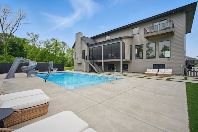 1004 NW Hugg Dr, Polk City, IA 50226 - view of pool featuring a water slide, a sunroom, an outdoor living space, and a patio