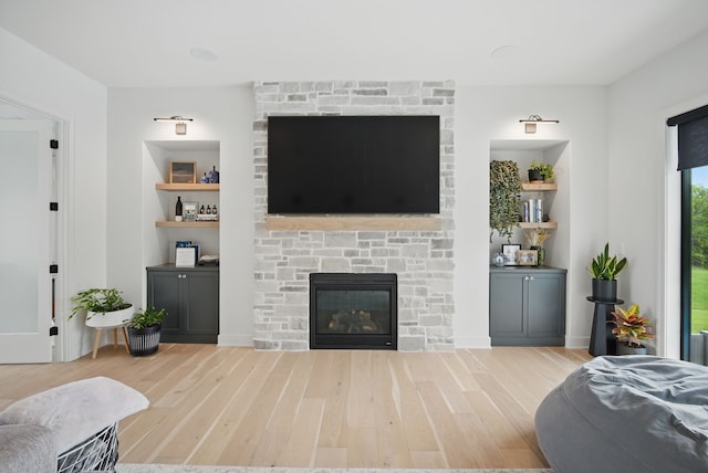 1004 NW Hugg Dr, Polk City, IA 50226 - living room with wood finished floors, a stone fireplace, and built in shelves