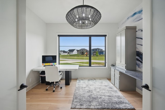 1004 NW Hugg Dr, Polk City, IA 50226 - office featuring light wood-style flooring, a chandelier, and built in study area