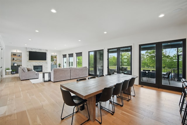 1004 NW Hugg Dr, Polk City, IA 50226 - dining space with a large fireplace, light wood finished floors, and recessed lighting
