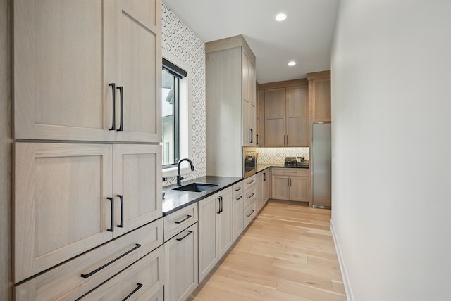 1004 NW Hugg Dr, Polk City, IA 50226 - kitchen with a sink, light wood-style flooring, light brown cabinetry, stainless steel refrigerator, and backsplash