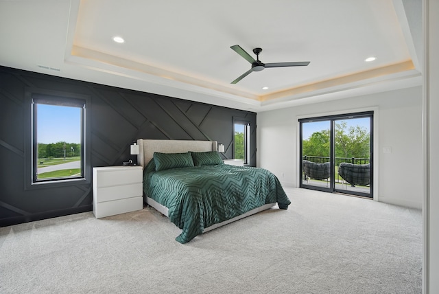 1004 NW Hugg Dr, Polk City, IA 50226 - carpeted bedroom featuring a tray ceiling, access to exterior, multiple windows, ceiling fan, and recessed lighting
