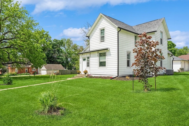 140 N 7th St, Carlisle, IA 50047 - back of house featuring cooling unit, a shingled roof, a yard, and a detached garage