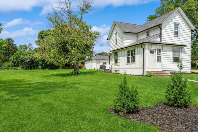 140 N 7th St, Carlisle, IA 50047 - view of property exterior featuring board and batten siding, a shingled roof, and a yard