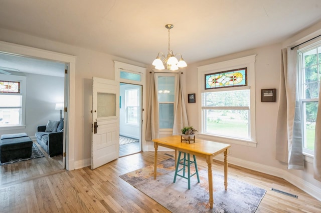 140 N 7th St, Carlisle, IA 50047 - dining area featuring light wood-style flooring, baseboards, and a chandelier
