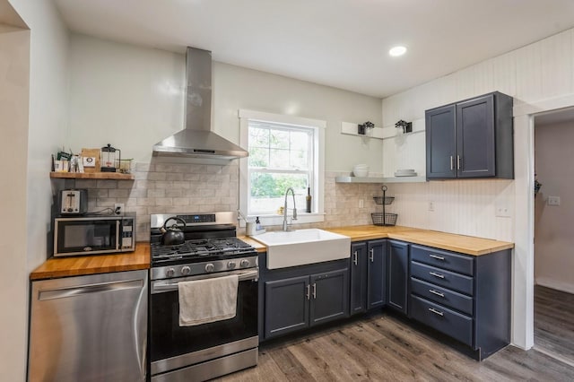 140 N 7th St, Carlisle, IA 50047 - kitchen featuring stainless steel appliances, wood counters, open shelves, wall chimney range hood, and recessed lighting