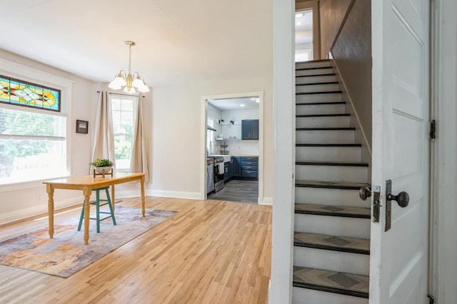 140 N 7th St, Carlisle, IA 50047 - stairway featuring wood finished floors, a chandelier, and baseboards