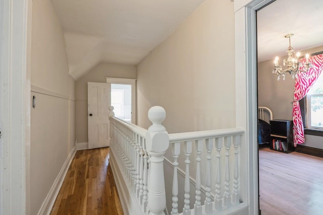 140 N 7th St, Carlisle, IA 50047 - hallway featuring an upstairs landing, wood finished floors, plenty of natural light, a chandelier, and lofted ceiling