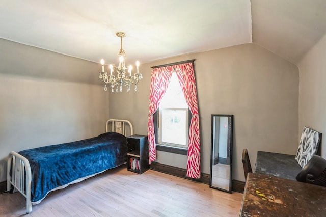 140 N 7th St, Carlisle, IA 50047 - bedroom featuring light wood-style floors, a chandelier, and lofted ceiling
