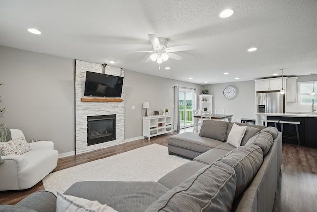 603 Elm Ct, Dallas Center, IA 50063 - living room with ceiling fan, a stone fireplace, plenty of natural light, recessed lighting, and dark wood-style flooring