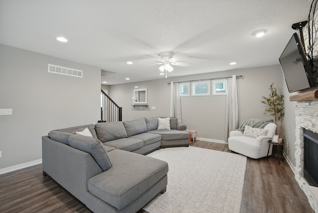603 Elm Ct, Dallas Center, IA 50063 - living room with a stone fireplace, ceiling fan, stairs, dark wood-style flooring, and recessed lighting