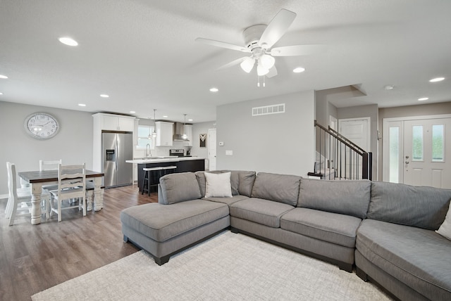 603 Elm Ct, Dallas Center, IA 50063 - living room with wood finished floors, ceiling fan, recessed lighting, and stairway