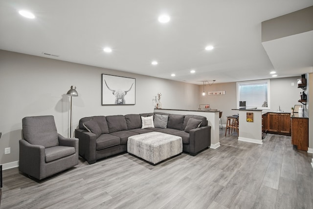603 Elm Ct, Dallas Center, IA 50063 - living room featuring light wood-style flooring, recessed lighting, and bar