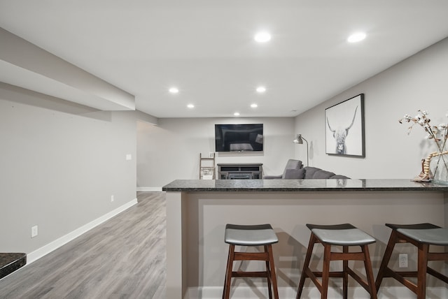 603 Elm Ct, Dallas Center, IA 50063 - kitchen with recessed lighting, light wood finished floors, a breakfast bar, and a fireplace