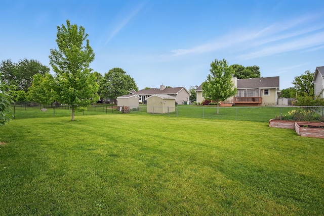 603 Elm Ct, Dallas Center, IA 50063 - fenced backyard with a wooden deck and a vegetable garden