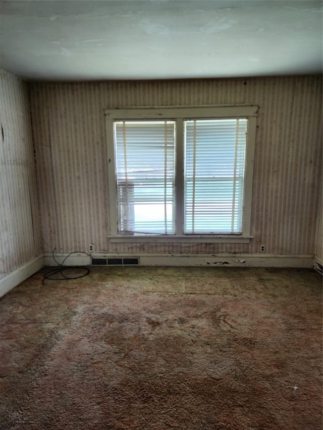 414 E Robinson St, Knoxville, IA 50138 - carpeted empty room with plenty of natural light and baseboards