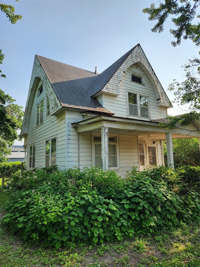 414 E Robinson St, Knoxville, IA 50138 - view of property exterior with a porch and roof with shingles