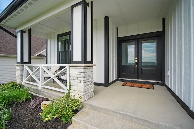 2216 Timberview Dr, Norwalk, IA 50211 - doorway to property featuring a porch, french doors, board and batten siding, and stone siding