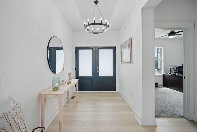 2216 Timberview Dr, Norwalk, IA 50211 - foyer featuring french doors, a chandelier, and light wood-style floors