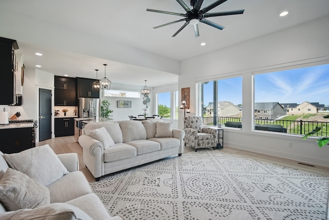 2216 Timberview Dr, Norwalk, IA 50211 - living area featuring light wood-style floors, a ceiling fan, recessed lighting, a chandelier, and baseboards