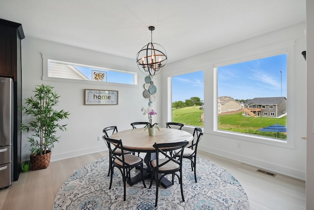 2216 Timberview Dr, Norwalk, IA 50211 - dining area with a chandelier, baseboards, and light wood finished floors